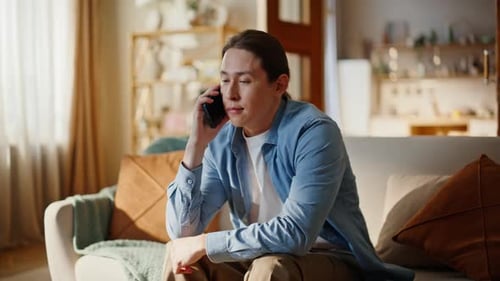 Young Man Talking on Phone Sitting on Couch