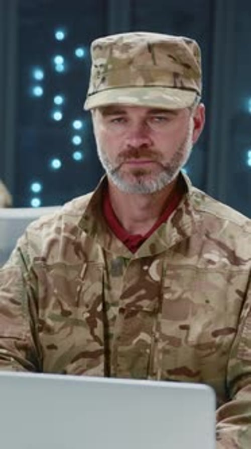 Army Soldier in Camouflage Using Laptop Computer Performing Webhosting Secure Operations Data Center