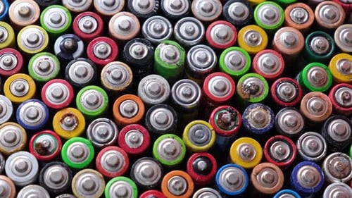 Pile of colorful AA batteries close up