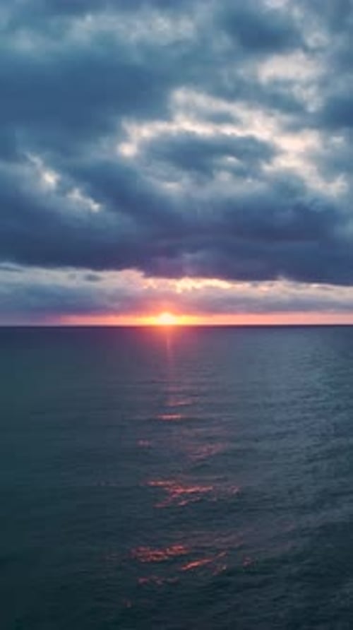 Vertical Video Majestic Sunset Above the Sea With Golden Rays Reflecting on the Ocean Surface
