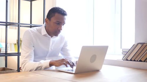 Stressed Young Adult Working at Office Laptop