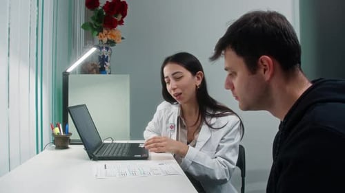 Doctor Explaining Medical Report to Patient During Clinic Consultation