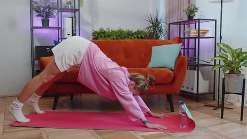 Woman Practicing Yoga Poses on Mat at Home