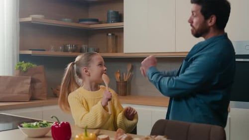 Father and Daughter Dancing in Kitchen at Home