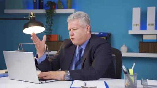 Frustrated Man Working on Laptop in Modern Office