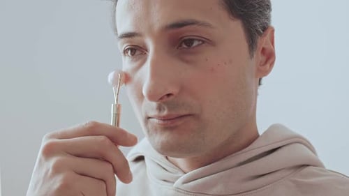 Young Adult Using Jade Facial Roller