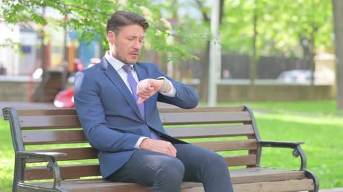 Man in Suit Sitting on Park Bench Waiting