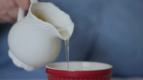 Pouring Liquid Into Small Red Ceramic Bowl