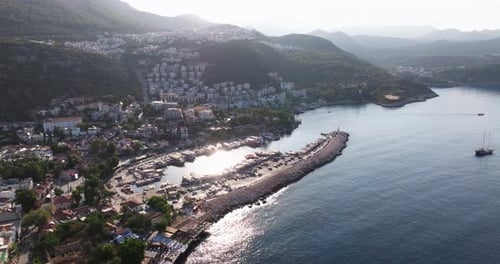Aerial dolly of Kas marina in Antalya, Turkey, with boats docked in the harbor and beautiful clear w