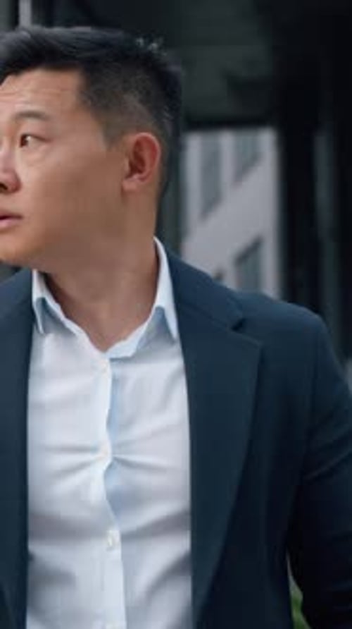 Man in Suit Checks Watch Outdoors in City