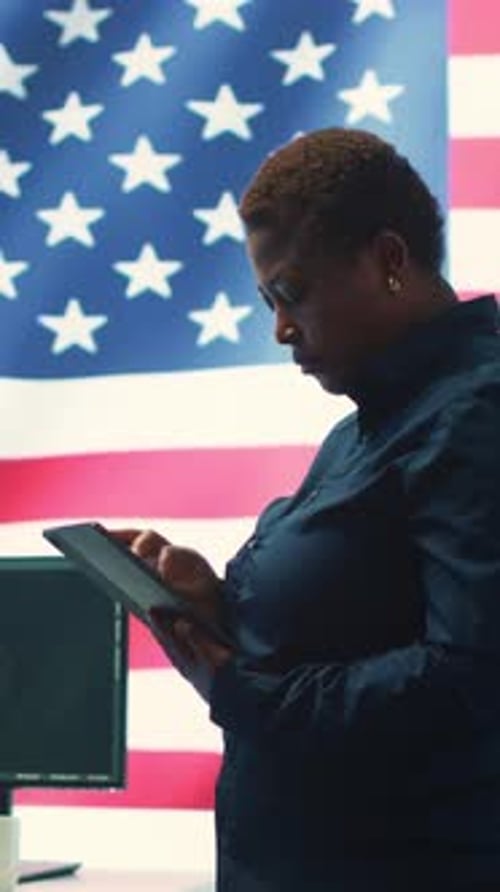 Woman Using Tablet in Front of American Flag