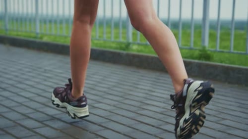 Legs Jogging on Urban Stone Path Close Up
