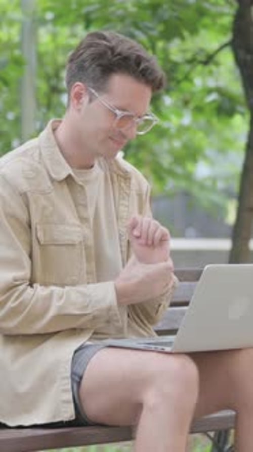 Young Man Working On Laptop in the Park