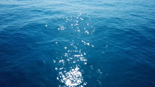 Imagens aéreas sobre a água do oceano com um verdadeiro brilho solar na água.