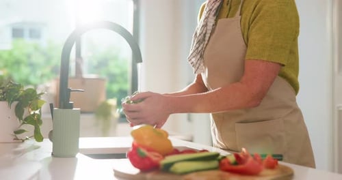 Woman Washing Vegetables at Kitchen Sink in Sunlight