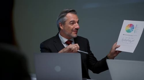 Man Explaining Charts During Corporate Meeting