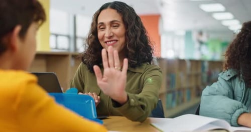 Teacher Gives Student High Five in Library