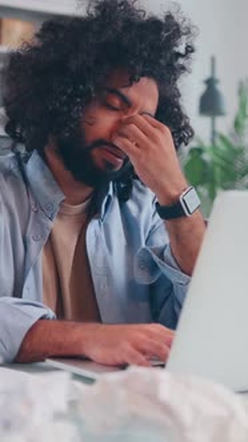 Young Adult Working at Computer with Tissues