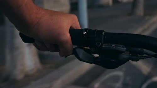 Point de vue en POV sur un vélo, gros plan d'une main sur un vélo, poignée d'une journée ensoleillée, mise en valeur
