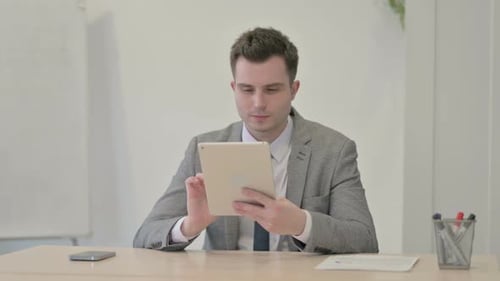 Young Adult Using Tablet in Bright Office
