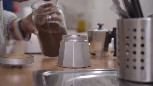 Mujer afroamericana irreconocible haciendo café en una olla de moka en casa