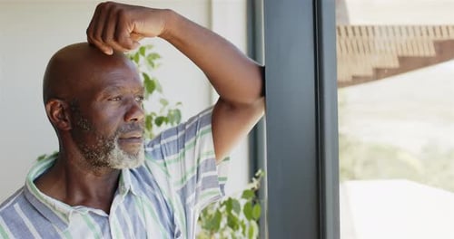 Man Looking out Window in Bright Home