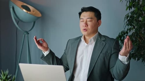 Man Meditating at Desk in Office Setting
