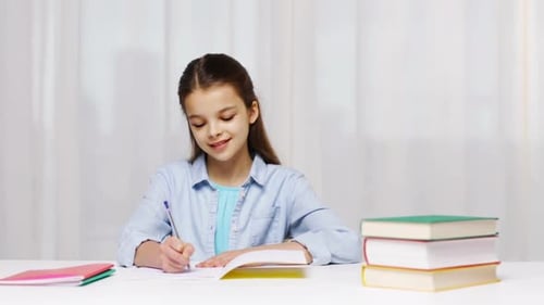 Education, People, Children And Learning Concept - Girl Hand Writing Math Task To Notepad At School