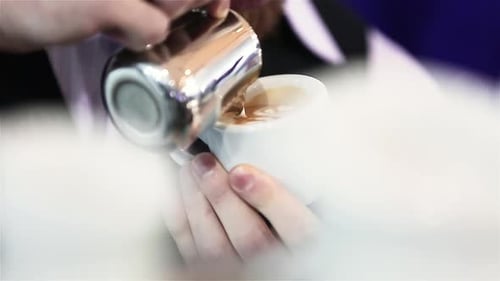 Barista Pouring Milk into Coffee Cup