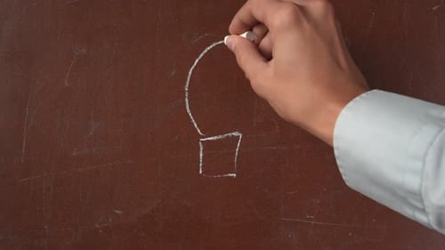 Textured Brown Chalkboard Background Male Hand Drawing a Sketchy Light Bulb and Arrows Around It on