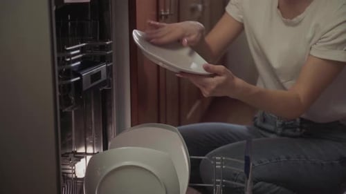 Woman Unloading Plates from Dishwasher