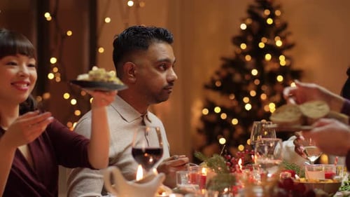 Friends Eating Holiday Dinner with Christmas Tree