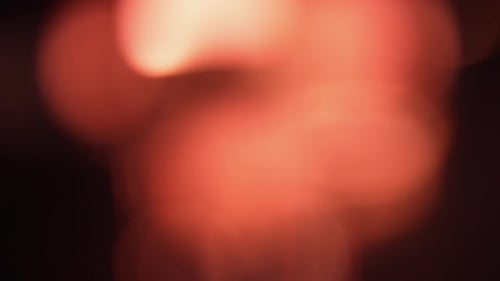 Abstrakter dunkler Hintergrund mit subtilem Rotlicht-Bokeh-Effekt, der für eine geheimnisvolle und stimmungsvolle Atmosphäre sorgt