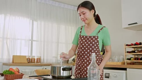 Asian young woman cooking healthy foods in kitchen in morning at home.