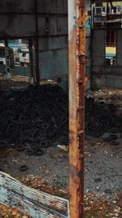 Old used tires in abandoned factory. Aerial view of an abandoned industrial plant. Vertical video