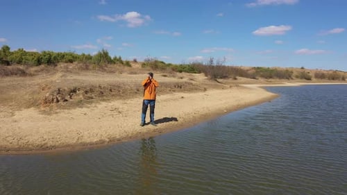 Man with Camera on Lake Bank