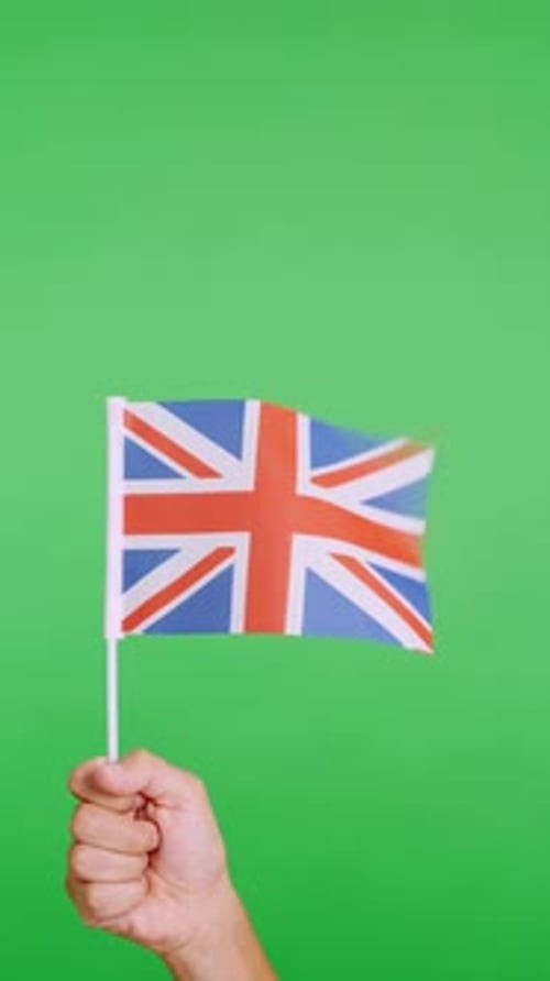 Hand Holding Flag of the United Kingdom Waving