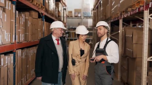A respectable elderly man communicates with warehouse workers