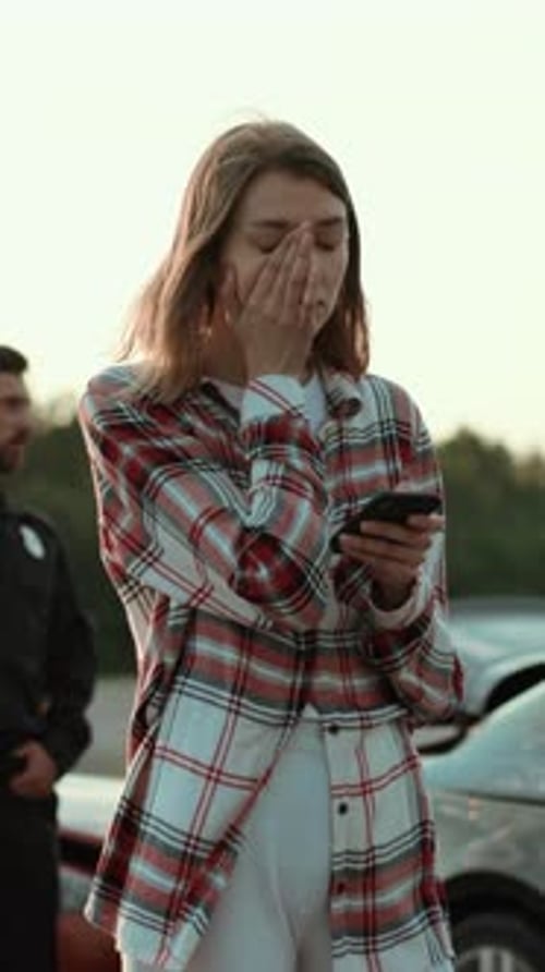 A Young Woman Fully Engrossed in Using Her Smartphone While Outdoors in the City
