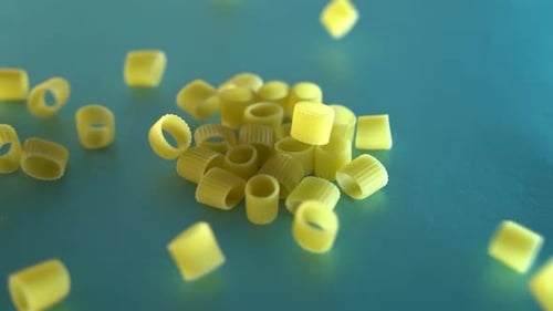 Ditalini Pasta Falling on Turquoise Surface