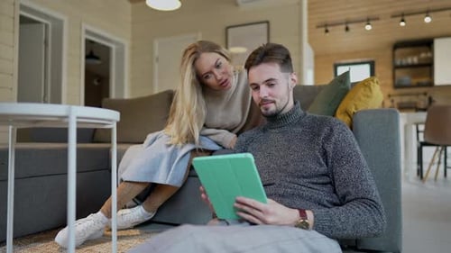 Couple Relaxing Indoors with a Tablet