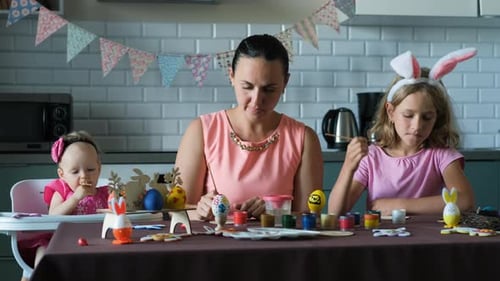 Mother and Daughters Painting Easter Eggs Together
