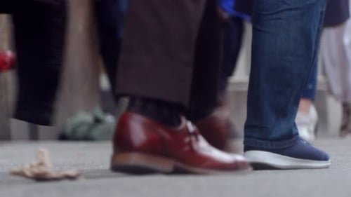 People walk on the street, close up to feet, shoes, boots, sneakers. Day time, busy street. Spring t