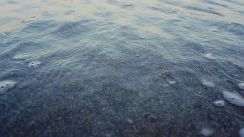 Blue Ocean Water Waves Splashing Sandy Beach in . Closeup Sea