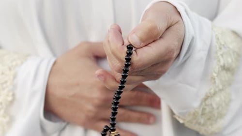 Person Holding Prayer Beads in Hands
