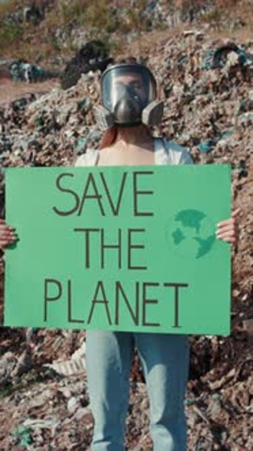 Woman with Gas Mask Holds Protest Sign