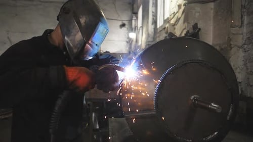 Arbeiter beim Schweißen von Schutzmasken im Metallbau in einer Metallfabrik Schweißer macht Fuge