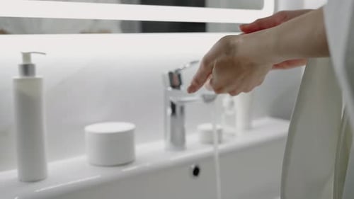 Woman Washing Hands in Bright Bathroom