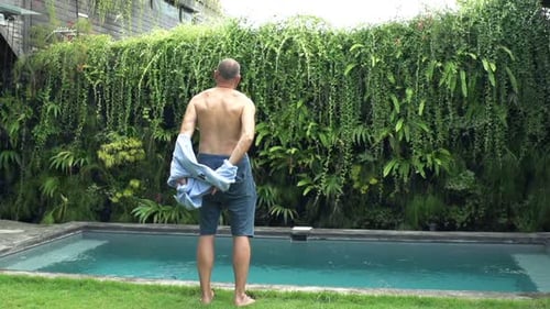 Man Taking Off Shirt and Stretching Arms in Garden 30s