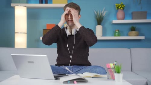 Young Adult Studying with Laptop at Home